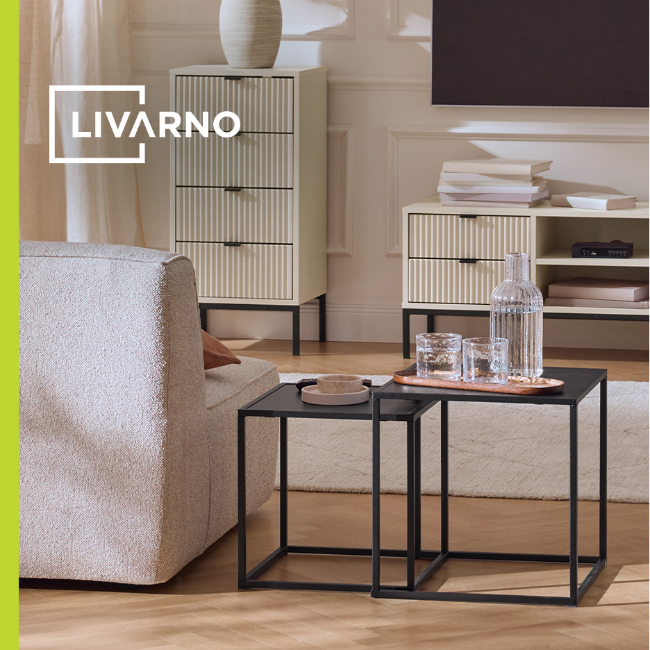 Dnevna soba sa bež komodama, TV ormarićem i crnim klub stolovima.