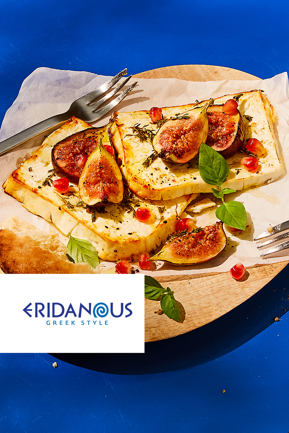 Grilovani sir sa smokvama, narom i začinskim biljem na drvenoj dasci.