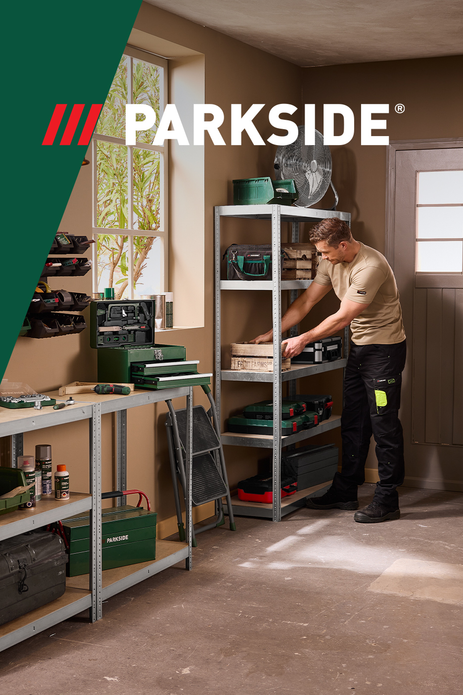 Muškarac u radionici sa policama, alatom i kutijama za alat.