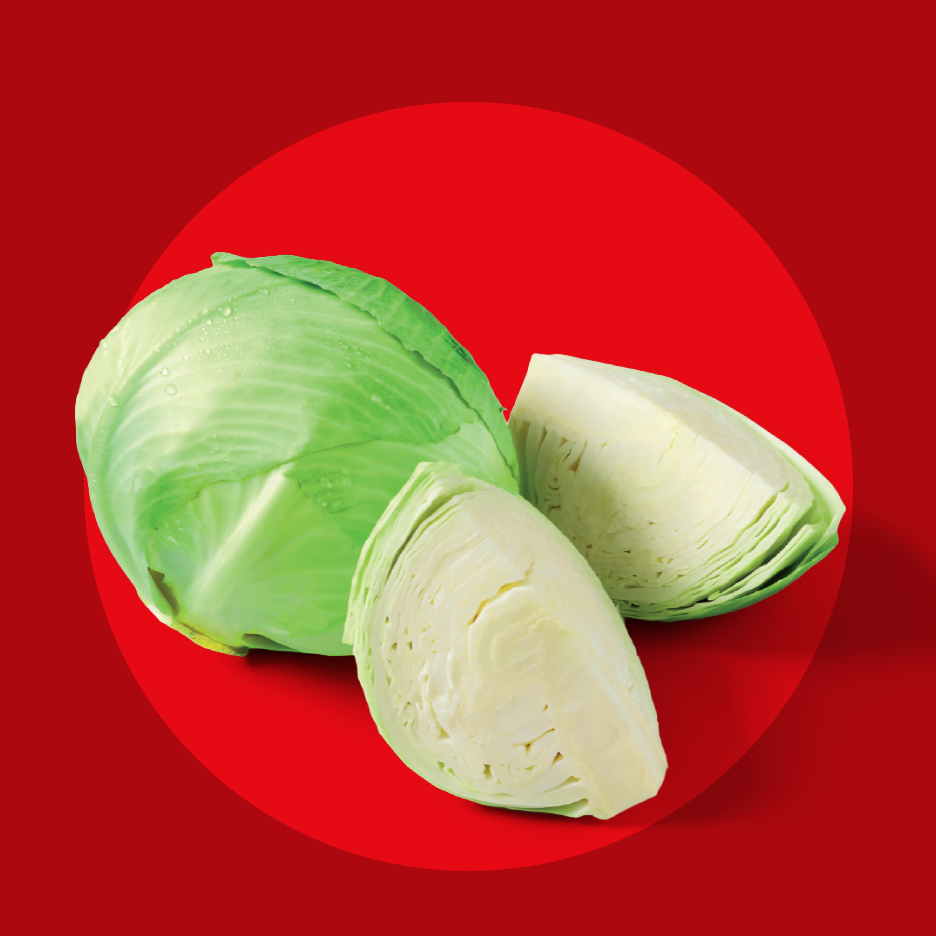 Zeleni kupus i dva isečena dela kupusa na crvenoj pozadini.