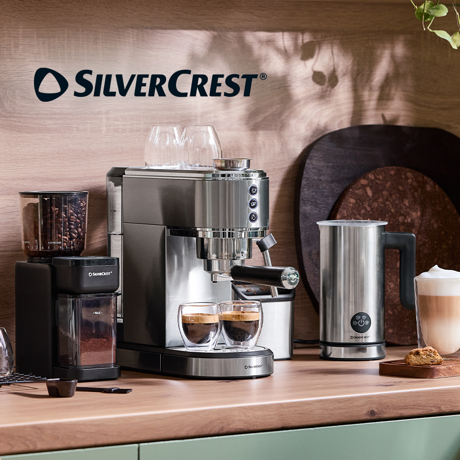 Aparat za espreso sa mlinom za kafu i penilom za mleko na kuhinjskom pultu.