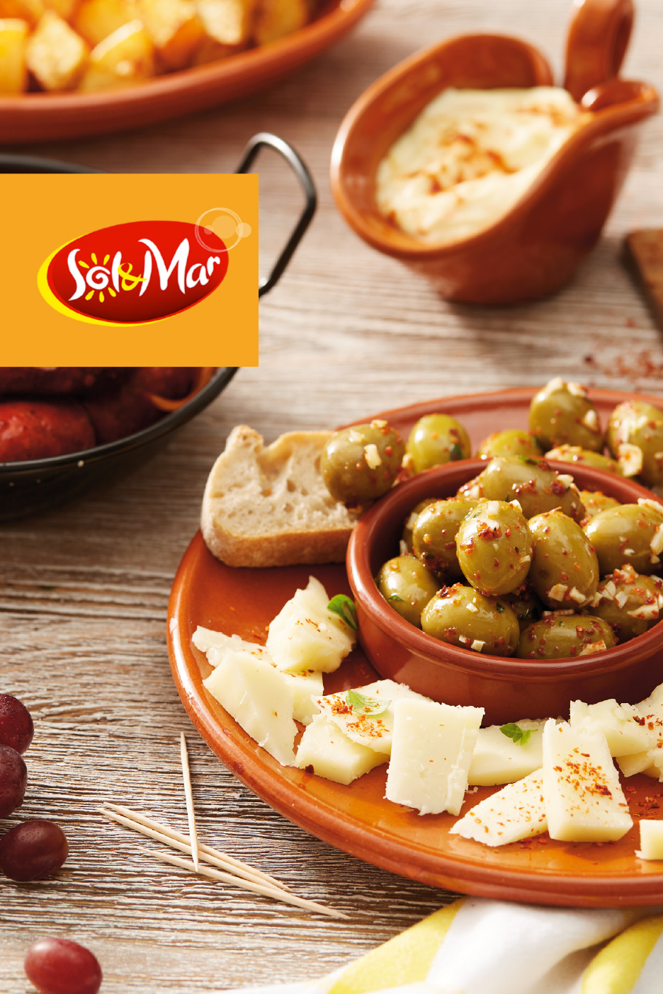 Tapas sa maslinama, sirom, hlebom i sosom, sa logotipom Sol & Mar.