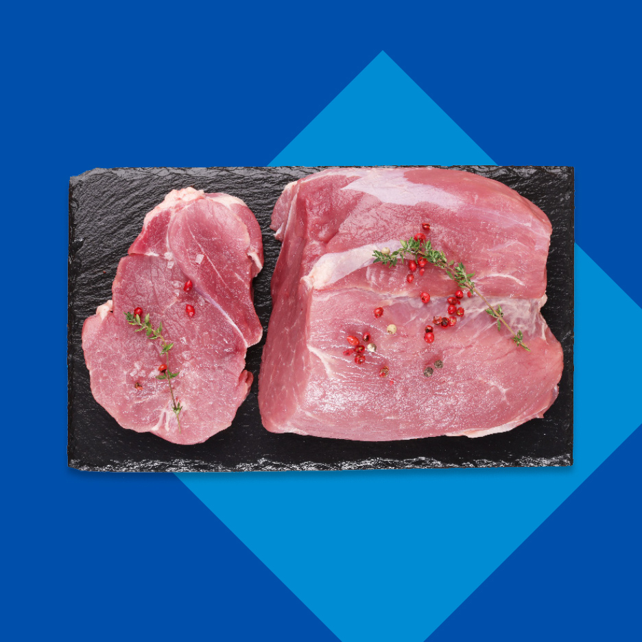 Sveže svinjsko meso sa začinima na crnoj ploči.