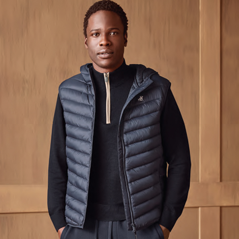 Muškarac u tamnoplavom prsluku sa kapuljačom i crnom rolkom.